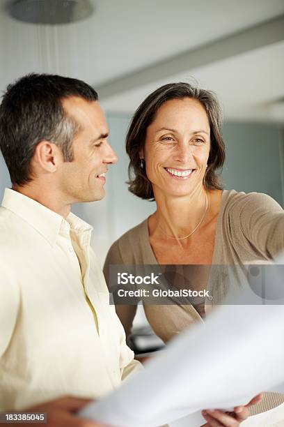 Happy Mature Couple Looking At Blueprints Of Their New House Stock Photo - Download Image Now