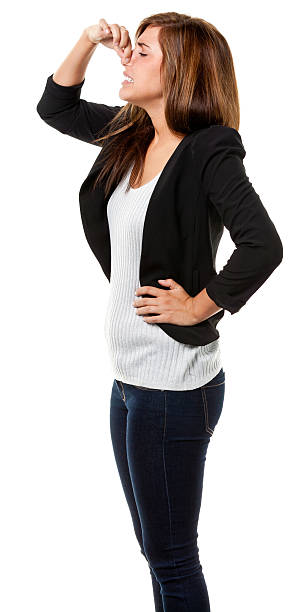 Young Woman Pinching Nose Side View Portrait of a young woman on a white background. http://s3.amazonaws.com/drbimages/m/peygin.jpg holding nose stock pictures, royalty-free photos & images