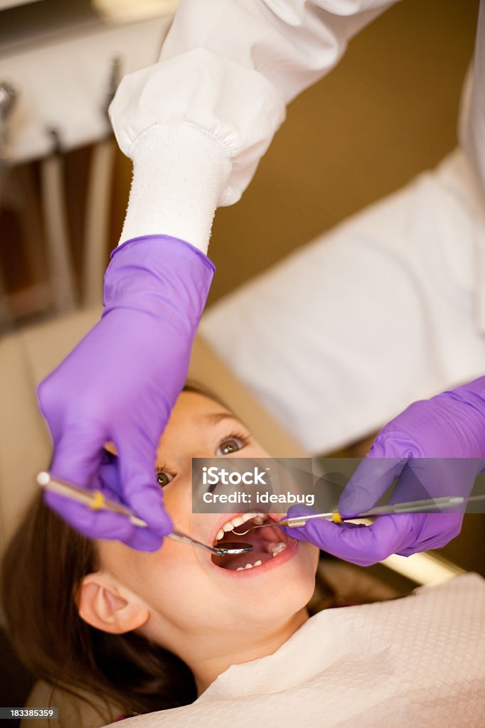 Giovane ragazza ottenere denti puliti in ufficio dentale di dentista - Foto stock royalty-free di 6-7 anni