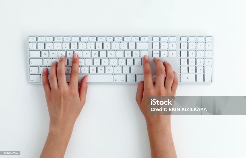 typing on keyboard. Female hands typing on a white computer keyboard. White background. Computer Keyboard Stock Photo