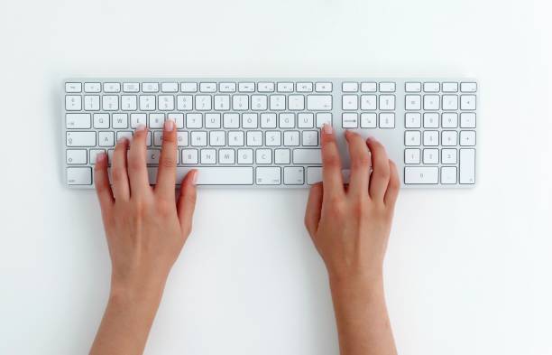 typing on keyboard. Female hands typing on a white computer keyboard. White background. enter key photos stock pictures, royalty-free photos & images