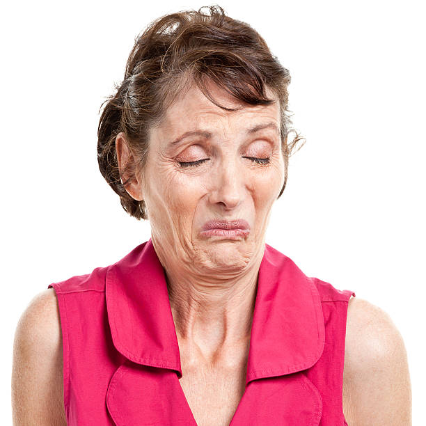 portrait of mature female making a face portraying disgust  - ogen dicht closeup vrouw 50 jaar stockfoto's en -beelden