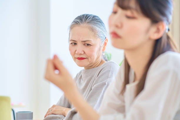 A senior woman looking at a young woman with a grim expression A senior woman looking at a young woman with a grim expression in the room annoying mother in law stock pictures, royalty-free photos & images