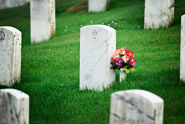 tombstone with flowers tombstone with flowers in graveyard tombstone stock pictures, royalty-free photos & images