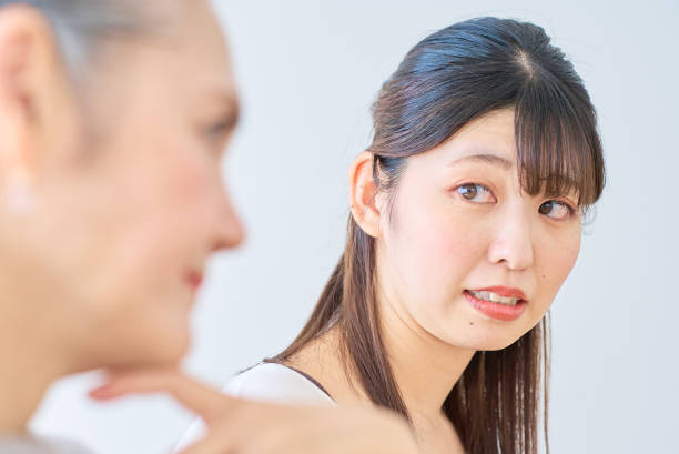 A young woman feels stressed next to a senior woman A young woman feels stressed next to a senior woman in the room annoying mother in law stock pictures, royalty-free photos & images