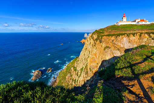 The historic lighthouse at Cabo da Roca or Cape Roca, an Atlantic ocean cape at the westernmost point of the Sintra Mountain Range and continental Europe near Lisbon, Portugal.