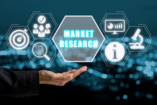 Market research concept, Business hand holding market research icon on virtual sceen with blue bokeh background.