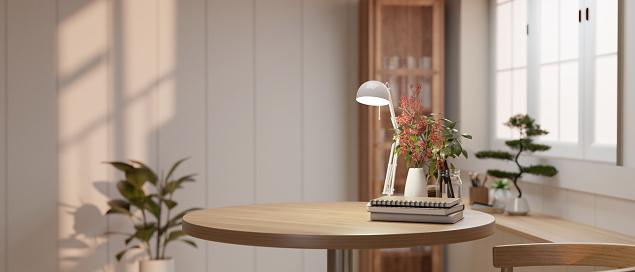 Close-up image of a copy space on a wooden table with a table lamp, books, and a flower vase in a modern and minimalist room. 3d render, 3d illustration