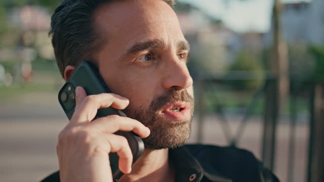 Emotional guy speaking smartphone call sunshine park closeup. Latin man calling