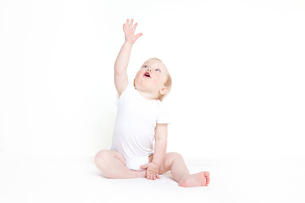 Baby girl reaching to the sky stock photo