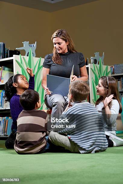 Storytime En La Biblioteca Foto de stock y más banco de imágenes de Contar una historia - Contar una historia, Niño, Salón de clase