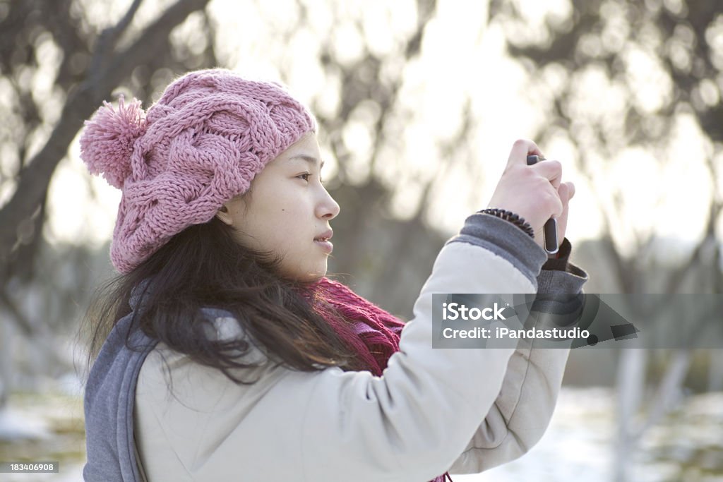 Girl in the snow field Beautiful asian girl in the snow field taking photos with a camera. Outdoors Stock Photo