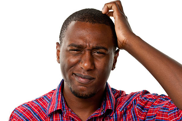 Confused young male scratching his head Portrait of a man on a white background. frowning headshot close up studio shot stock pictures, royalty-free photos & images