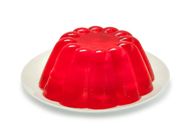 Red Jello Jelly A red jello (jelly in the UK) isolated on a white background. gelatin dessert stock pictures, royalty-free photos & images
