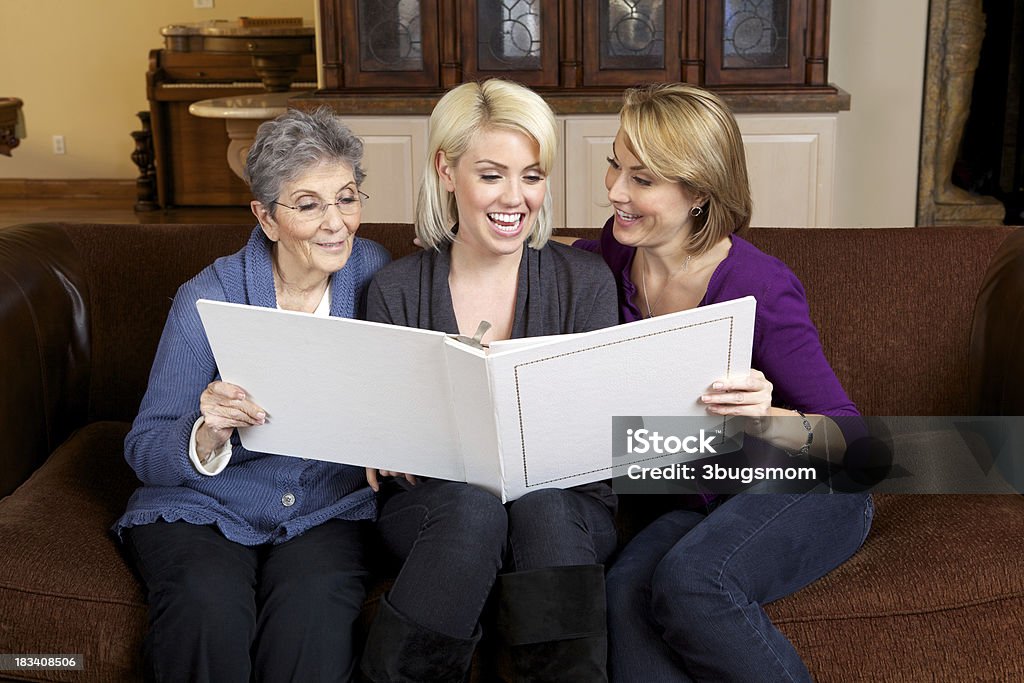 Tre generazioni di Belle Donne guardando un Album fotografico - Foto stock royalty-free di 35-39 anni