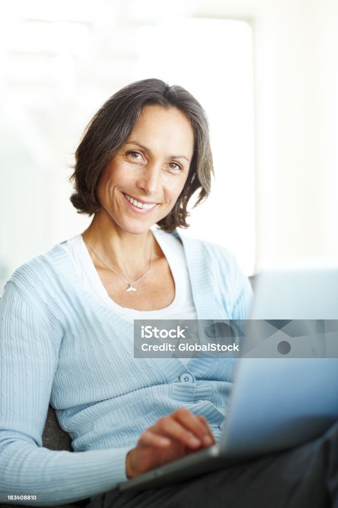 Sorridente Mulher Madura sentado com um computador portátil - Royalty-free 40-49 Anos Foto de stock