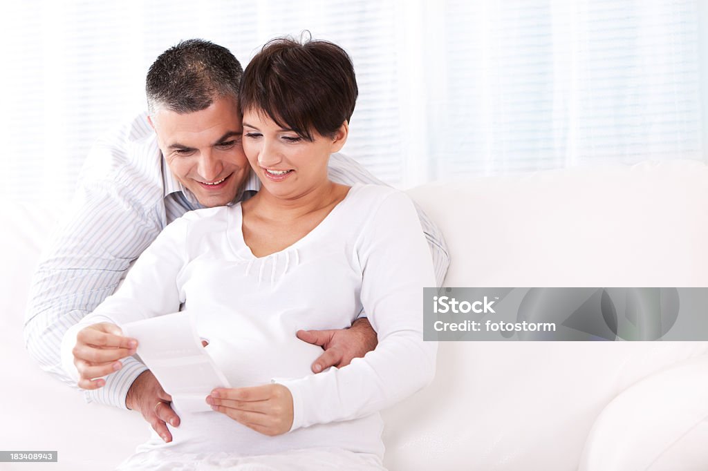 Szczęśliwy w ciąży Młoda para Patrząc na USG obrazu - Zbiór zdjęć royalty-free (Antycypacja)
