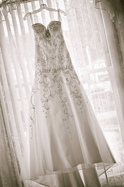 istock traditional wedding dress hanging in a curtained window 183409474
