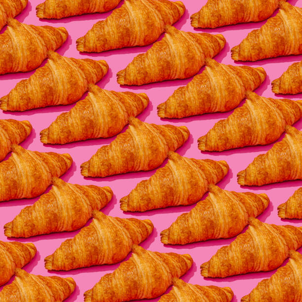 istock a pattern of croissants on a pink background 1834097296