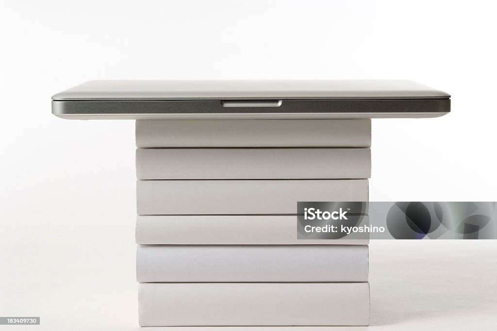 ノートパソコンにスタックド白い背景の上に空白の書籍 - いっぱいになるのロイヤリティフリーストックフォト