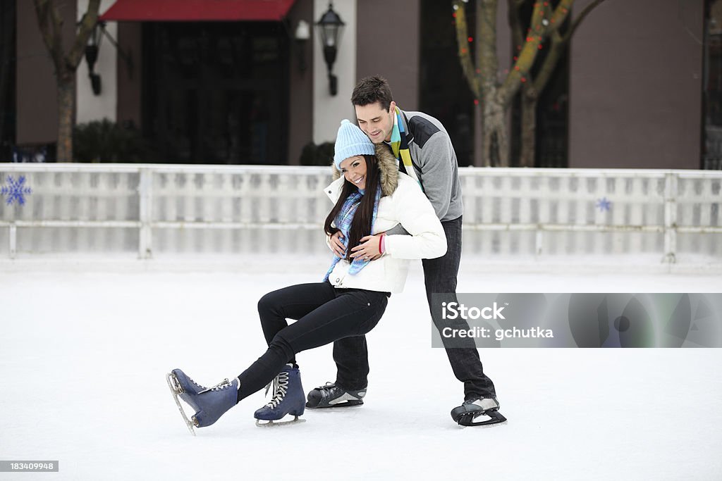 Falling On Ice Skates XXXL.  Young couple ice skating at an outdoor city skate rink. 20-29 Years Stock Photo
