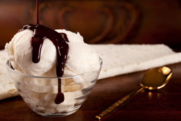バニラアイスクリーム、チョコレートシロップ、ゴールドのスプーン - chocolate topping ストックフォトと画像