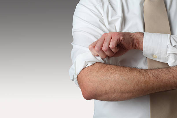 Rolling Up  Sleeves A man rolling up his sleeves. Clipping path around the man included. rolled up sleeves stock pictures, royalty-free photos & images