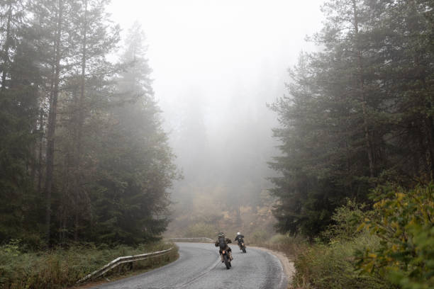 motorcycle stands on a foggy road in the rain