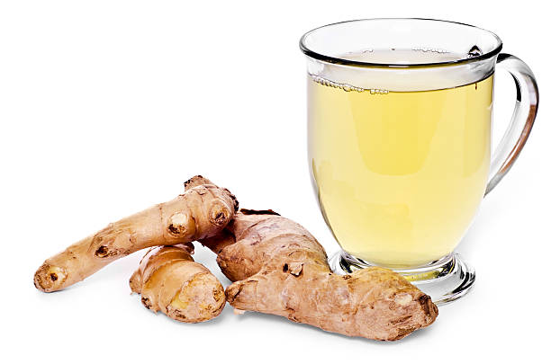 Glass of tea and ginger root on white background stock photo