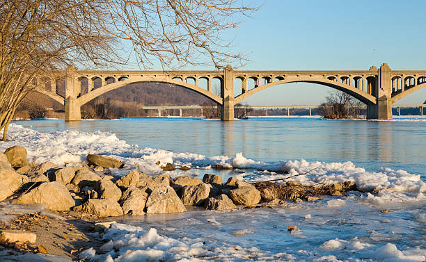 columbia-wrightsville bridge avec de la neige sur la rive du fleuve susquehanna - bridge pennsylvania susquehanna river concrete photos et images de collection