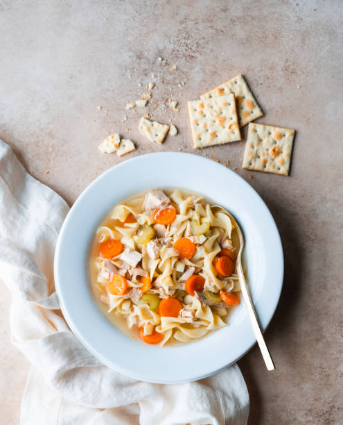istock Top view chicken noodle soup in white bowl on beige background. 1834142669