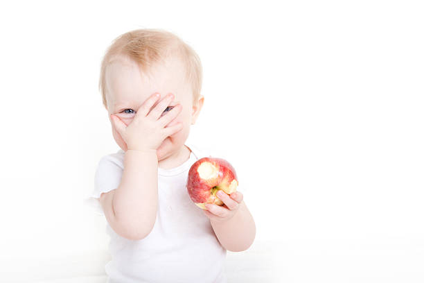 Baby girl with an apple stock photo