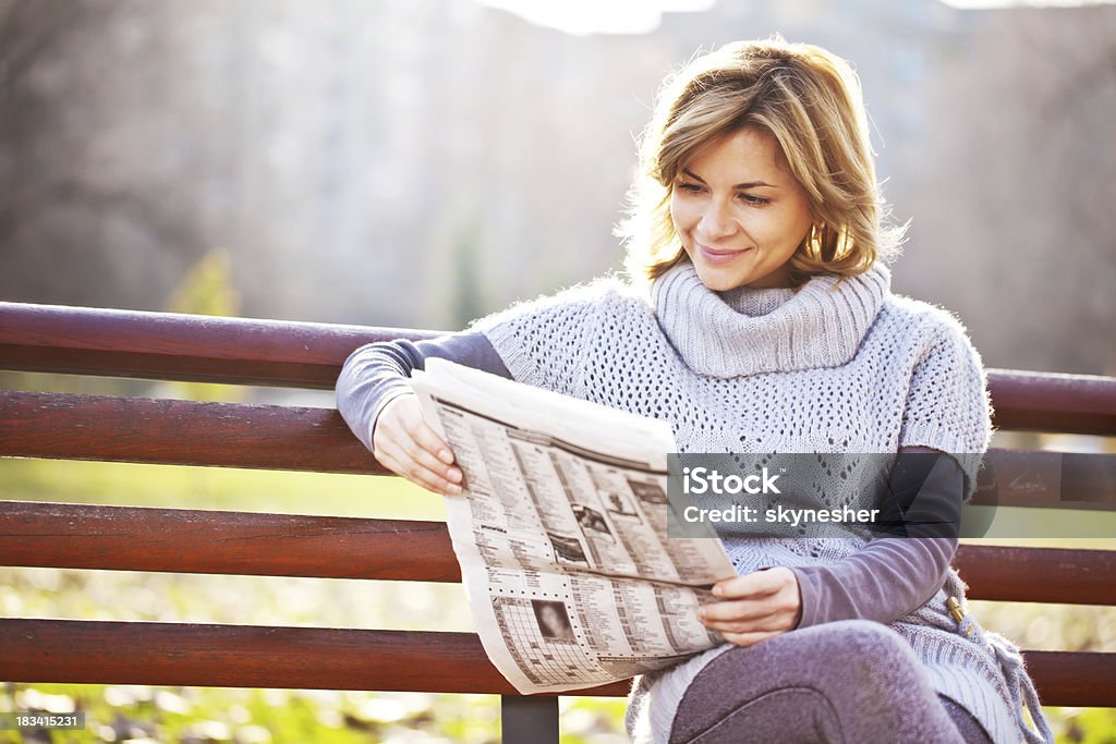 Красивая женщина читает газету на парк. - Стоковые фото Газета роялти-фри