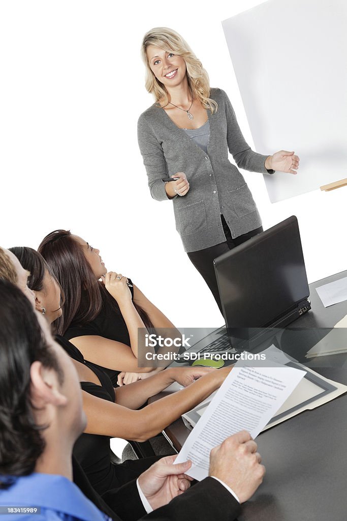 Donna d'affari dando presentazione durante una riunione di lavoro - Foto stock royalty-free di Piccolo gruppo di persone