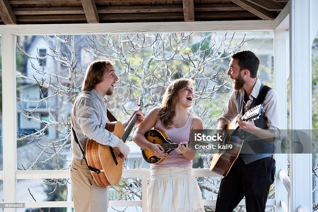 Musicians singing and playing instruments Young band playing country music, with guitars and banjo Country and Western Music Stock Photo