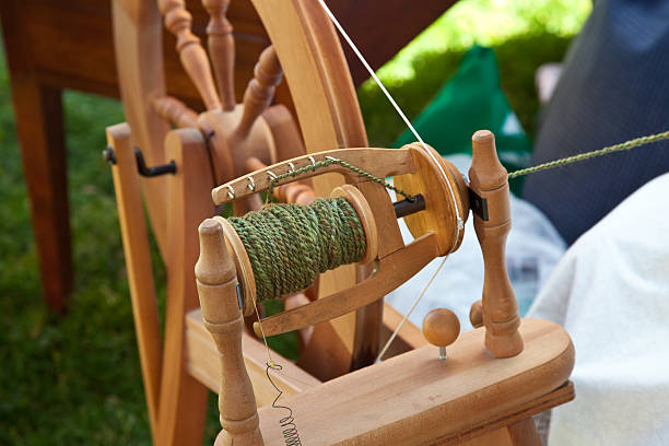 Spinning wheel with green wool yarn stock photo
