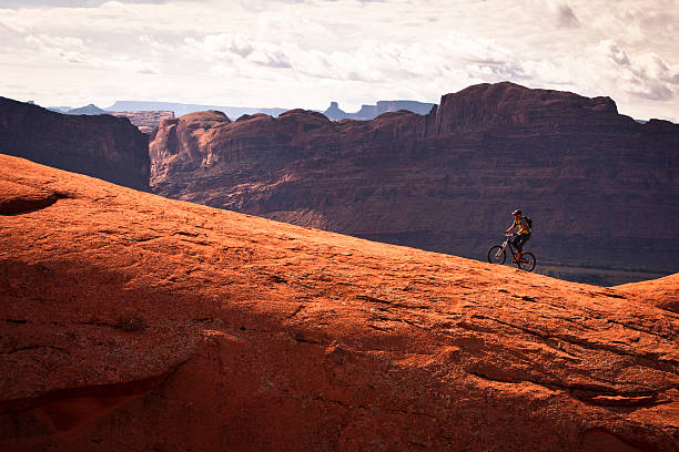 mountain biker climbing on slick rock. biking in Utah. slickrock trail stock pictures, royalty-free photos & images