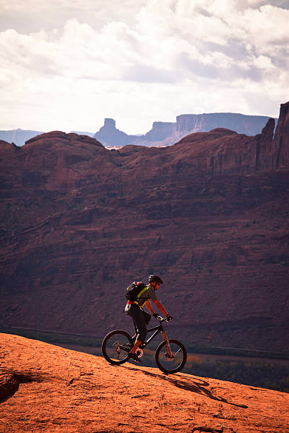 mountain biker climbing on slick rock. young male biking in Utah slickrock trail stock pictures, royalty-free photos & images