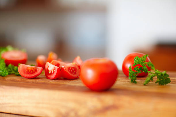 Closeup of sliced tomato and parsley on wooden board
