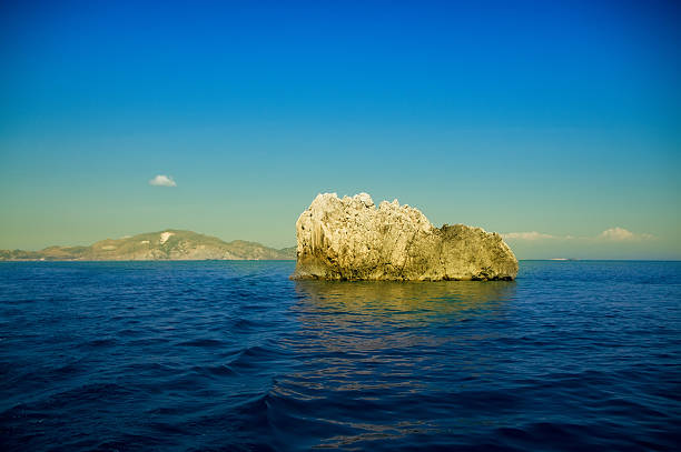 Clear blue sky over Small Rocky and Sunny Island in the middle of the ocean.See more images like this in: