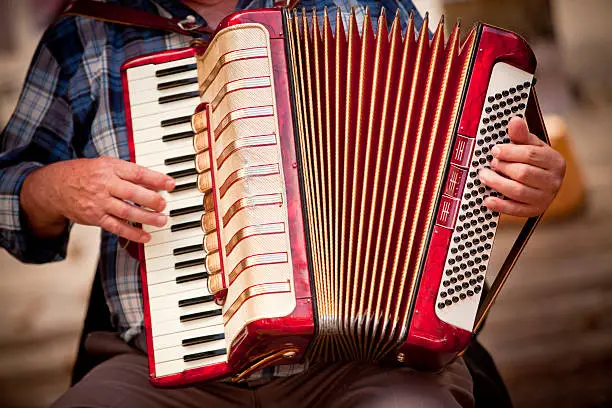 Street performer playing music on a vintage accordion squeeze box