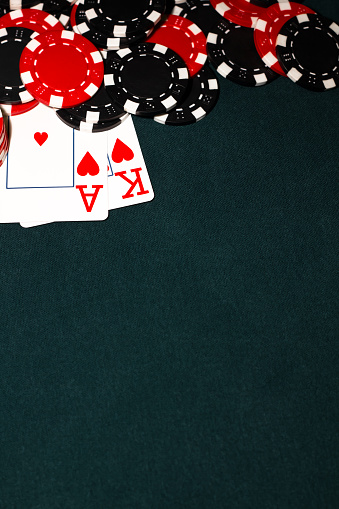 Ace King of Hearts with black and red poker chips set against a green felt poker table.