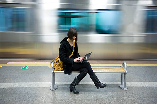 giovane donna con un computer alla stazione della metropolitana - train subway station people subway train foto e immagini stock