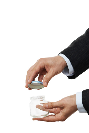 Businessman in suits is opening/closing the empty jar