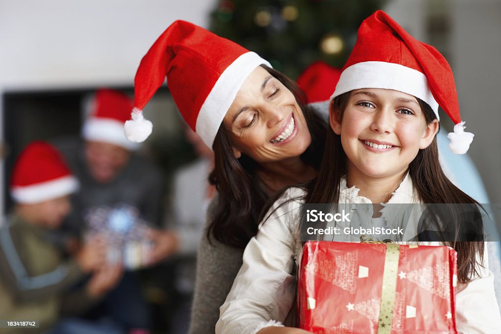 Felice Madre e figlia tenendo un regalo di Natale - Foto stock royalty-free di Adulto