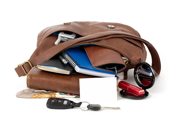 Blank Business Card and Purse Spilling Contents Blank business card propped against contents spilling out of a brown leather purse. Studio isolated on white with light shadows. phone wallet keys stock pictures, royalty-free photos & images
