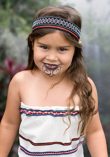 Young Traditional Maori Girl young maori girl dressed in traditional clothes with moku bay of islands new zealand stock pictures, royalty-free photos & images