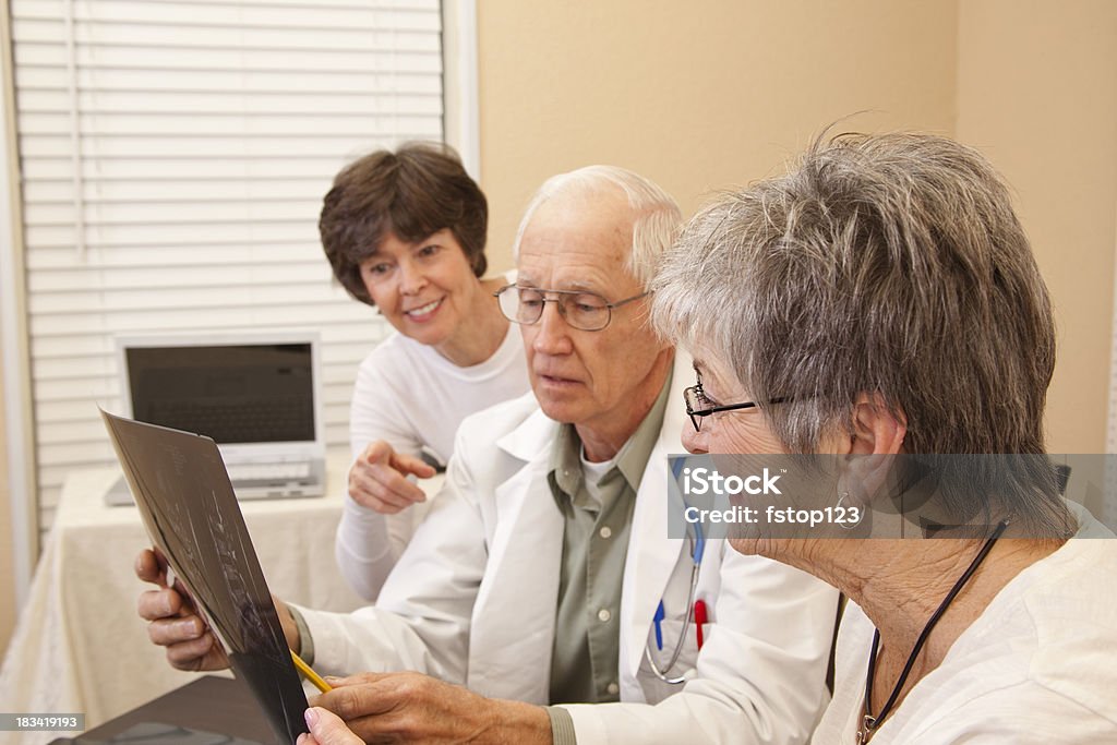 Senior woman with family and doctor. Senior woman with doctor and family member. 60-69 Years Stock Photo
