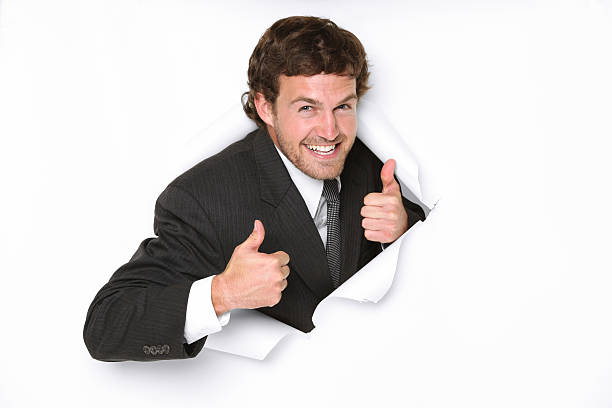 istock Confident businessman emerging through a hole in white paper 183419208