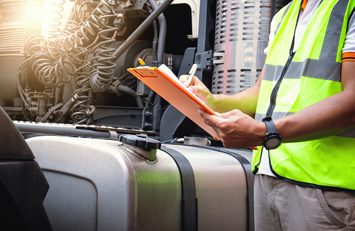 Truck Drivers Checking the Semi Truck's Fuel Tank. Mechanic Repairman Auto Service. Diesel Truck. Maintenance Checklist. Lorry Fixing. Truck Inspection Safety Driving.